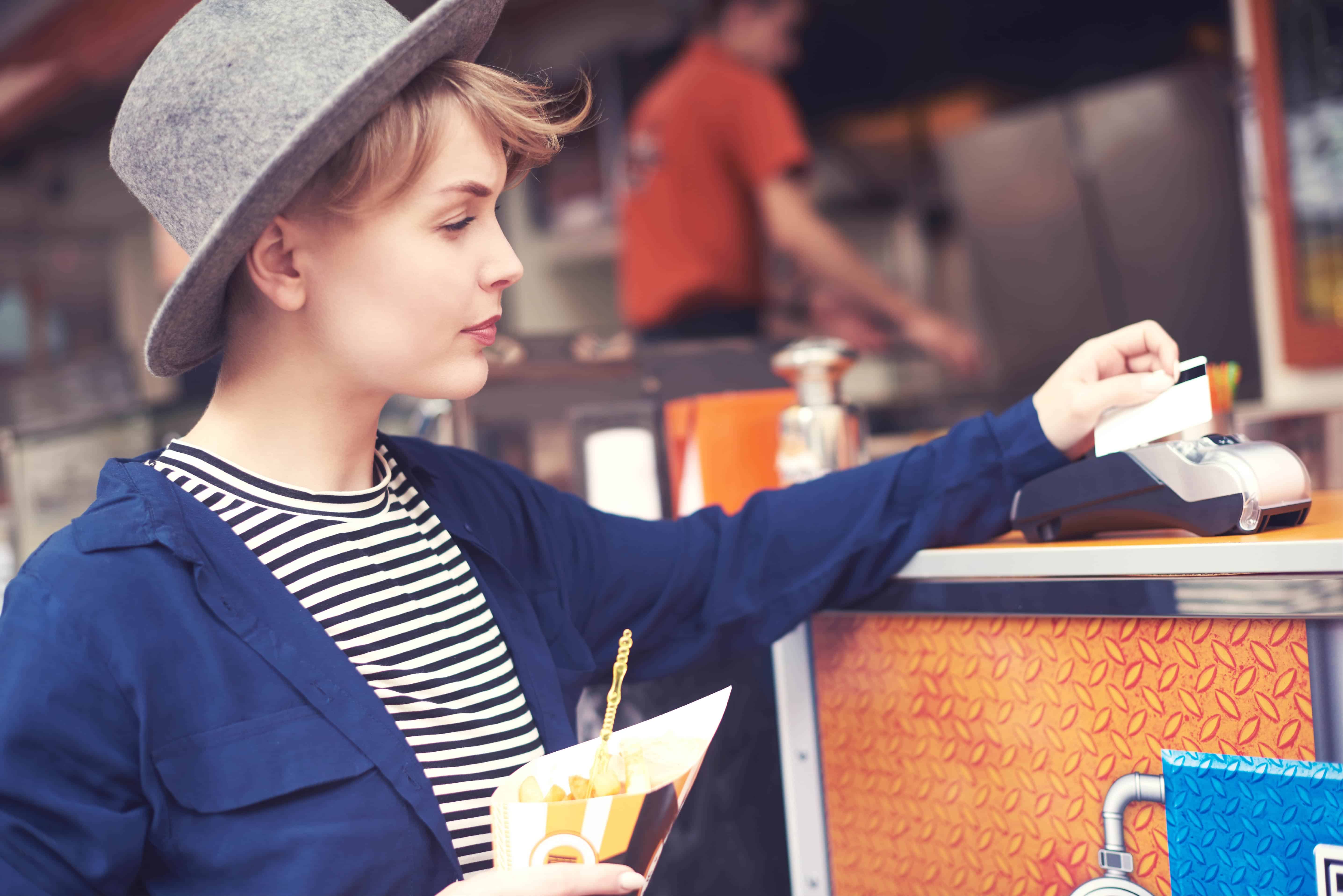 A woman paying by tapping her card at the terminal.